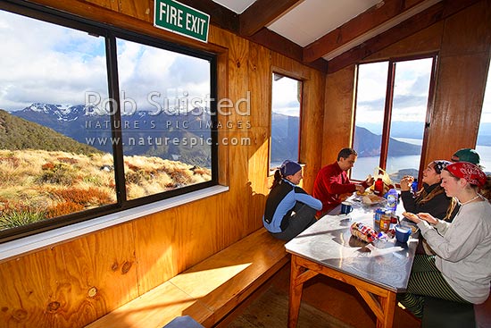 Trampers / hikers having breakfast at Luxmore Hut, first hut on Kepler Track Great Walk. Lake Te Anau beyond, Fiordland National Park, Southland District, Southland Region, New Zealand (NZ)