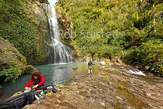 Trampers cooking lunch at Kitekite waterfall (Kitakita) on Glen Esk stream and the Hillary Trail track near Piha Beach. Waitakere Ranges Regional Park, Waitakere Ranges, Auckland, Waitakere City District, Auckland Region, New Zealand (NZ)