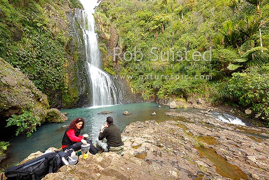 Trampers having lunch and brew at Kitekite waterfall (Kitakita) on Glen Esk stream and the Hillary Trail track near Piha Beach. Waitakere Ranges Regional Park, Waitakere Ranges, Auckland, Waitakere City District, Auckland Region, New Zealand (NZ)