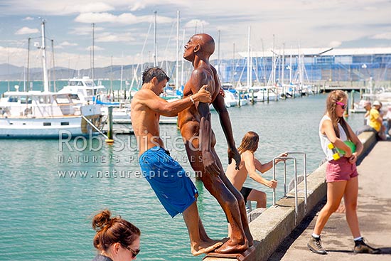 Wellington City waterfront, swimmers enjoying the summer day on wharf near Chaffers Marina. Sculpture Solace in the Wind by Max Pattie, Wellington, Wellington City District, Wellington Region, New Zealand (NZ)