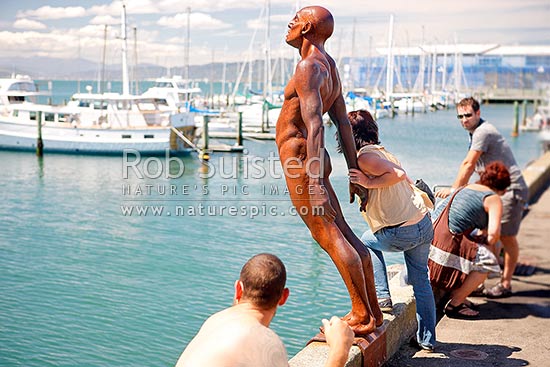 Wellington City waterfront, swimmers & visitors enjoying the summer day on wharf near Chaffers Marina. Sculpture Solace in the Wind by Max Pattie, Wellington, Wellington City District, Wellington Region, New Zealand (NZ)