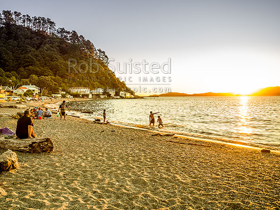 Days Bay at dusk on a perfect evening. Families and friends enjoying a warm evening and swimming in Wellington Harbour, Days Bay, Hutt City District, Wellington Region, New Zealand (NZ)