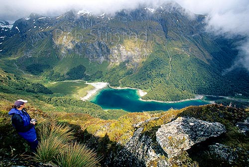 Tramper on the Routeburn Track Great Walk high above Lake 